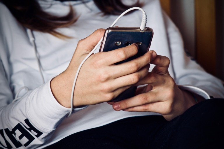 一人でリラックスしながらスマートフォンを使っている人のイメージ