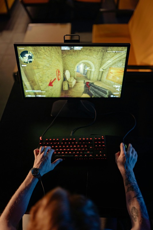 暗い部屋でひとりゲームをする人のイメージ