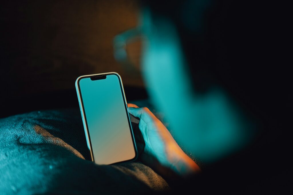 夜にひとりでスマホを見る人のイメージ