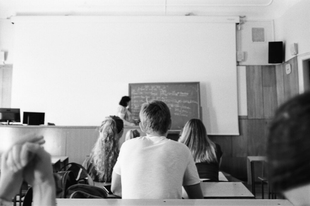 大学の講義室で一人で授業を受ける人のイメージ